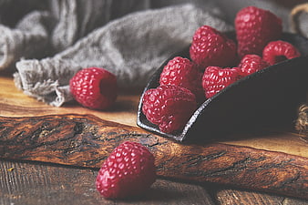 Fresh Raspberries in Black Scoop on Rustic Wood