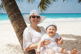 Happy Mother and Baby Smiling on Tropical Beach
