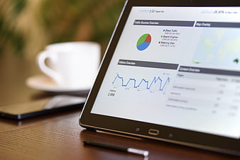 Tablet displaying digital marketing analytics dashboard on wooden desk