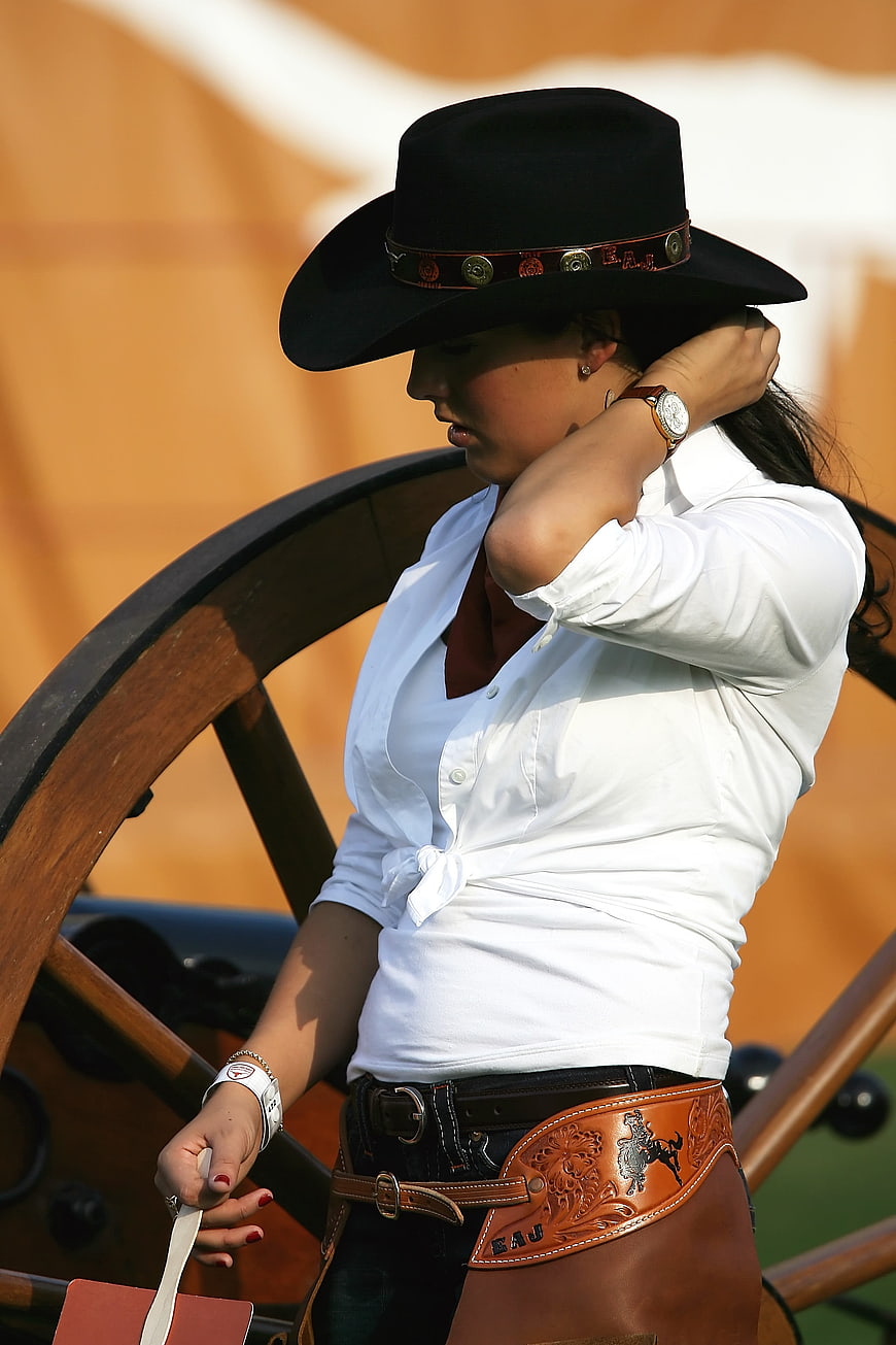 Young Cowgirl in Western Attire with Wagon Wheel