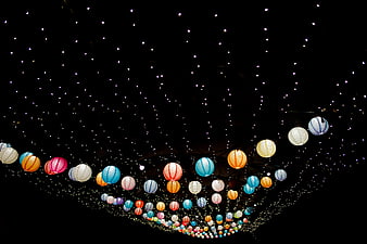 Colorful paper lanterns and fairy lights against a dark night sky