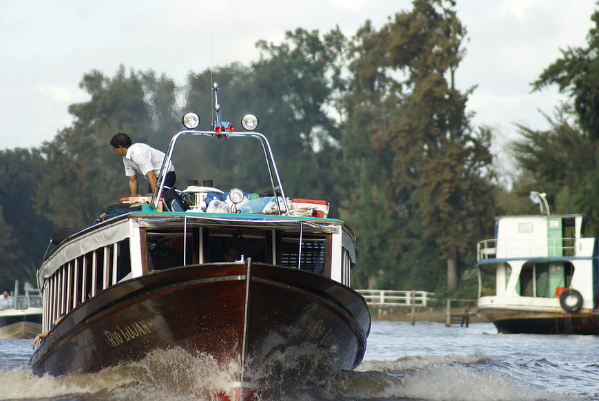Traditional wooden boat navigating the Argentine Delta river