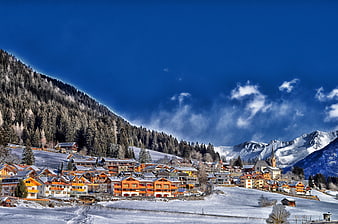 Snowy Alpine Village with Vibrant Blue Sky and Mountains
