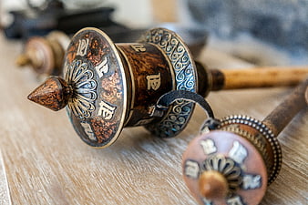 Close-up of traditional Tibetan Buddhist prayer wheels on wooden surface