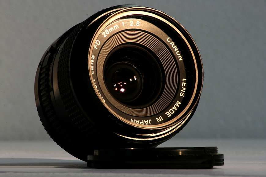 Vintage Canon FD 28mm Camera Lens on Gray Background