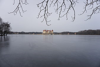 Moritzburg Castle reflected on frozen lake in winter