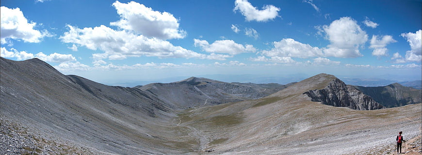 Panoramic mountain landscape with hiker and blue sky