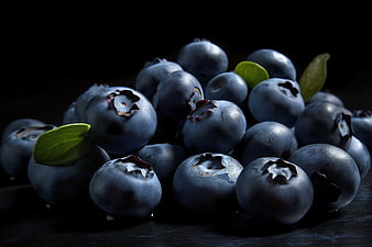 Fresh Blueberries with Green Leaves on Dark Background