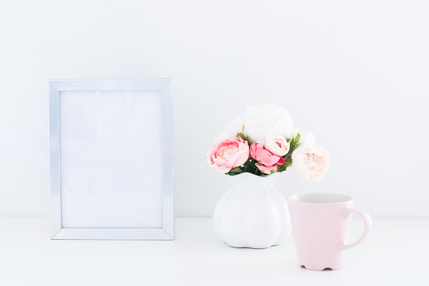 Minimalist white photo frame mockup with pink flowers and mug