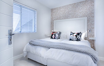 Modern Minimalist Bedroom With White Bedding And Exposed Brick Accent Wall