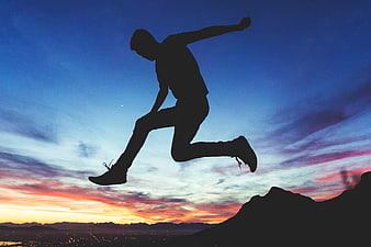 Silhouette of Man Jumping Against Sunset Sky