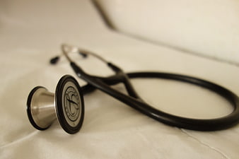 Close-up of black stethoscope on white medical sheet