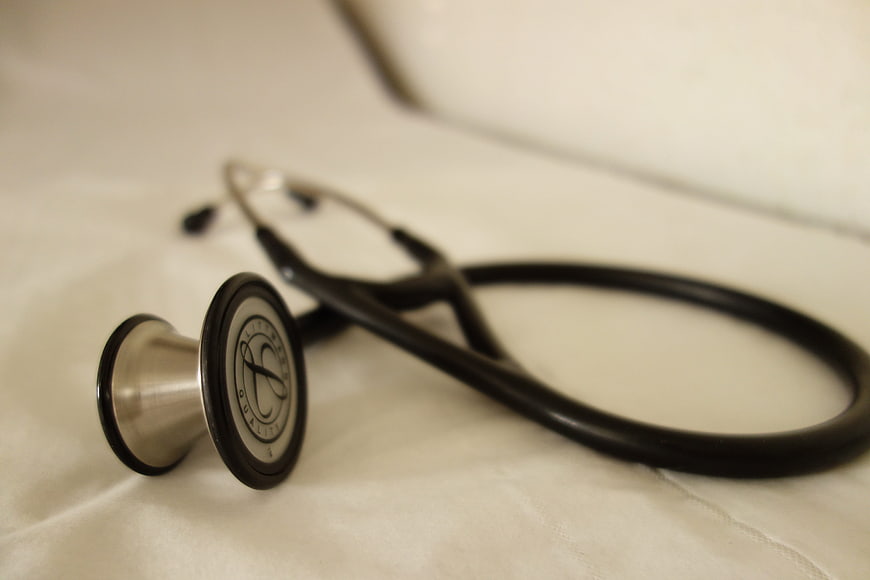 Close-up of black stethoscope on white medical sheet