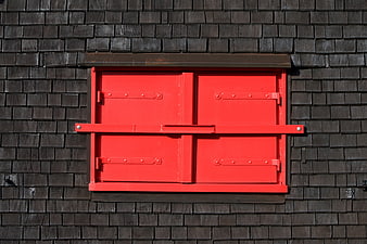 Closed Red Window Shutters on Dark Shingled Wall
