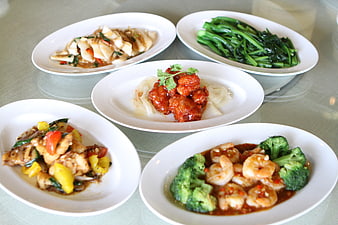 Five assorted Chinese dishes served on white plates