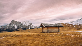 Solitary wooden cabin in snowy mountain landscape