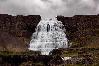 Majestic Tiered Waterfall Cascading Over Dark Volcanic Rocks