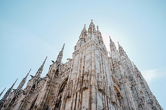 Low angle view of Milan Cathedral spires against blue sky