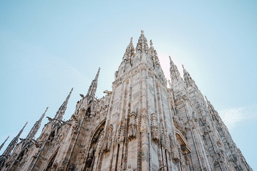 Low angle view of Milan Cathedral spires against blue sky