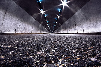 Low angle view of empty asphalt road inside concrete tunnel