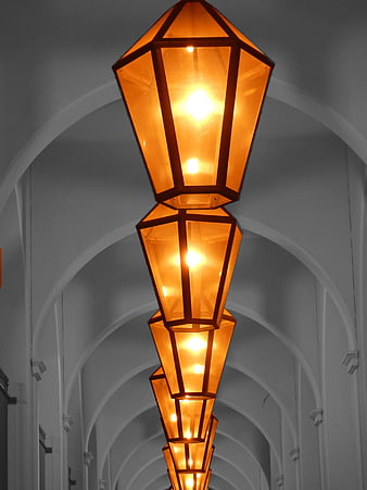 Vertical Row of Orange Lanterns in Arched Hallway