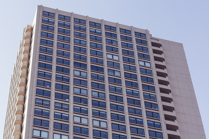 Low angle view of modern beige office building facade