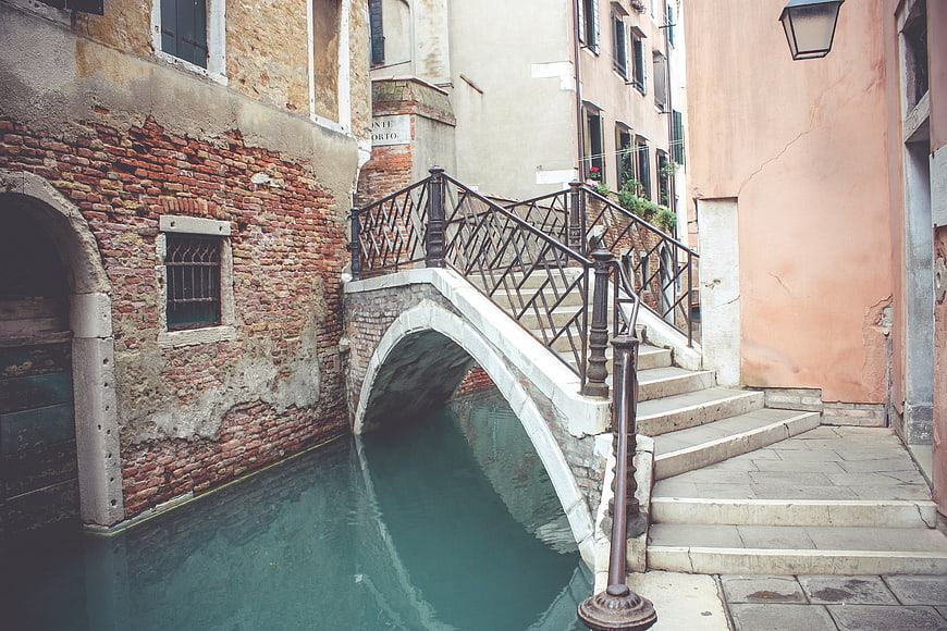 Venetian canal bridge with weathered brick buildings