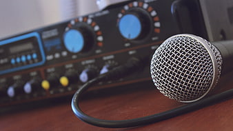 Close-up of Microphone and Audio Mixer on Wooden Desk