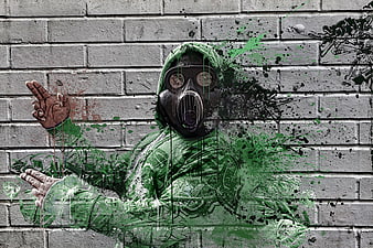 Graffiti of man in gas mask and green hoodie on brick wall
