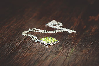 Silver Peridot Necklace on Dark Wood Background
