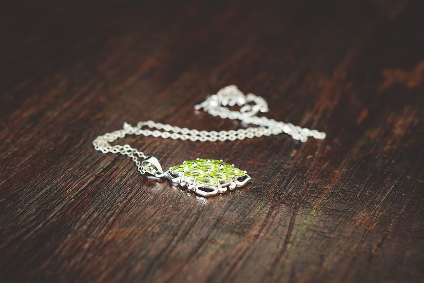 Silver Peridot Necklace on Dark Wood Background