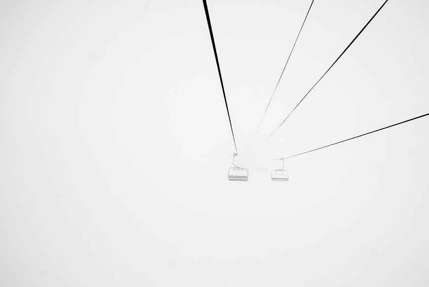 Minimalist Ski Lift Chairs in Heavy Fog