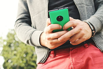 Man Holding Green Smartphone Outdoors