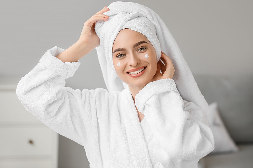 Smiling Woman in White Bathrobe with Towel on Head