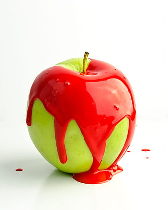 Green Apple Dripping with Red Glaze on White Background