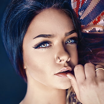 Close-up portrait of a young woman with striking blue eyes and dark hair