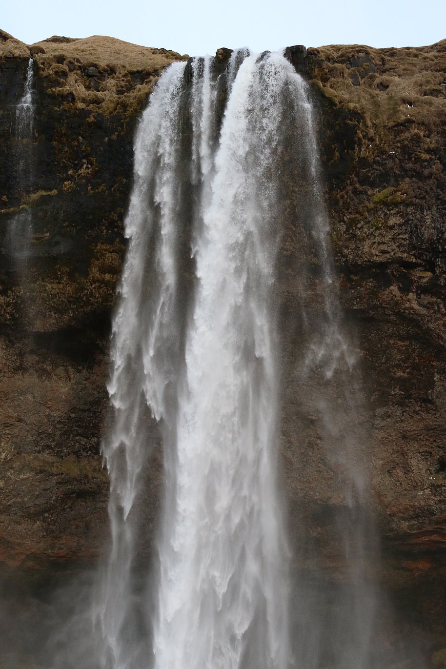 Powerful waterfall cascading down mossy cliff face