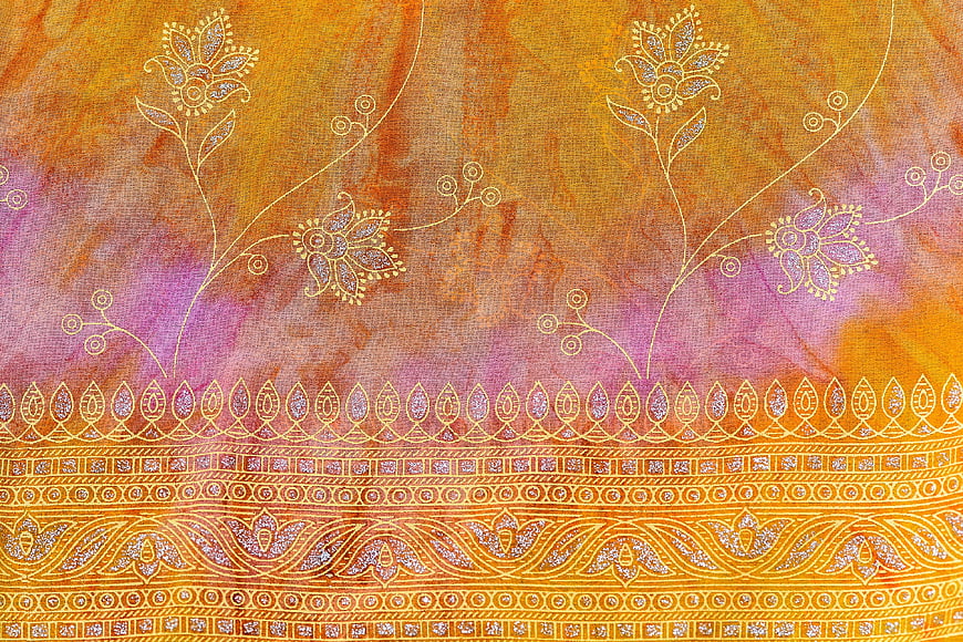 Textured fabric with intricate floral embroidery and golden patterns