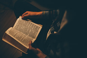 Man Reading Bible in Dark Room