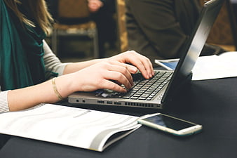 Close-up of Woman Typing on Laptop at Desk