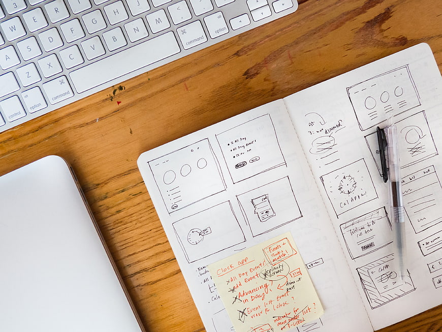 UX Design Sketches on Notebook with Keyboard and Laptop