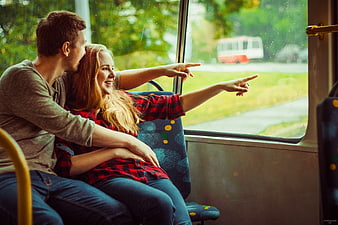 Happy couple pointing out window on trolleybus