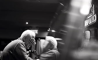 Senior man resting head in hand at dimly lit bar