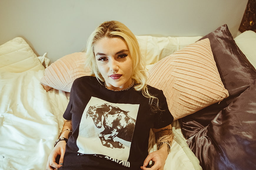 Blonde Woman Relaxing on Bed with Graphic Tee