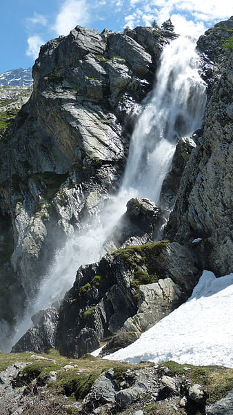 Majestic Alpine Waterfall Cascading Down Rocky Cliff