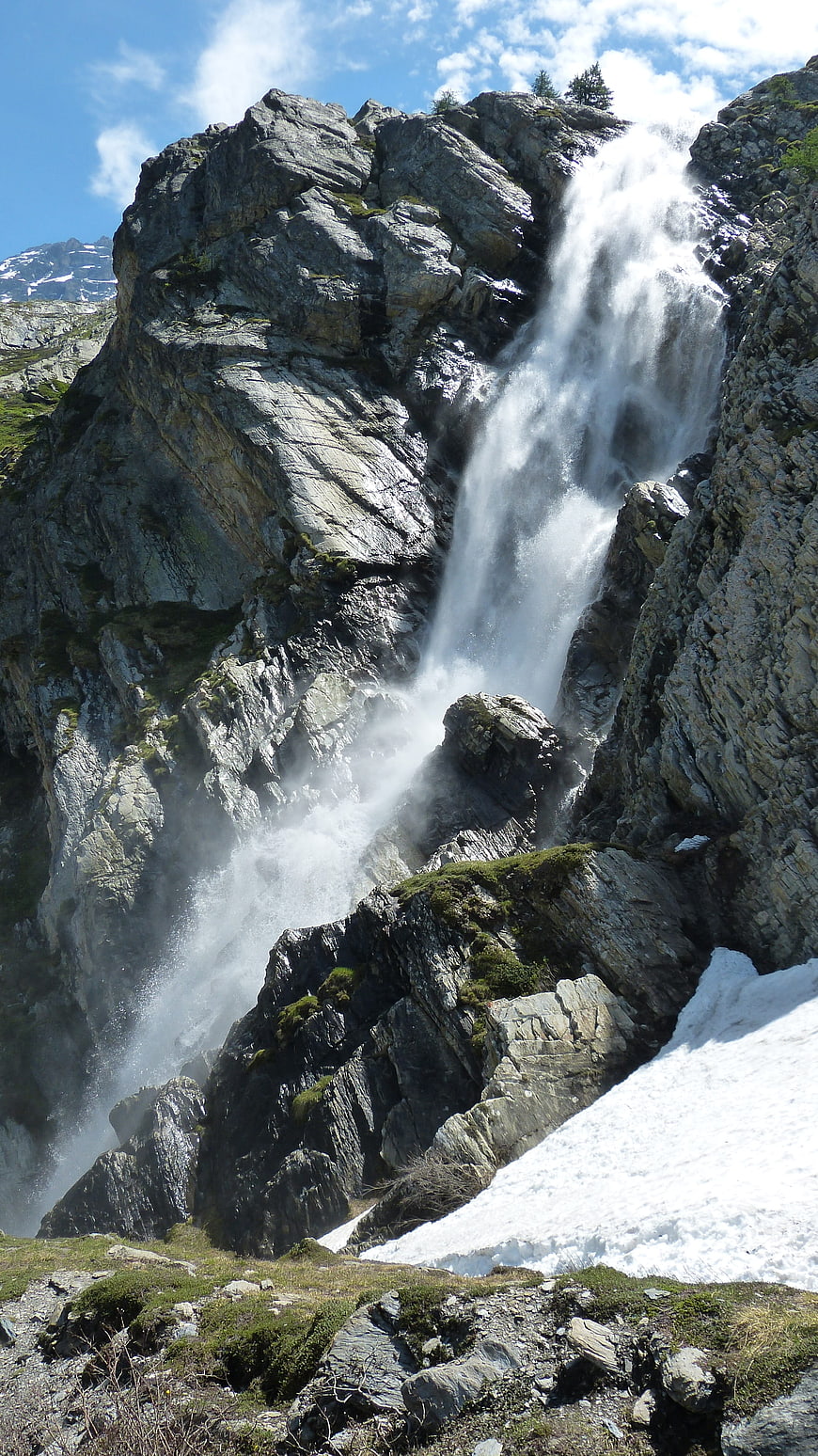 Majestic Alpine Waterfall Cascading Down Rocky Cliff
