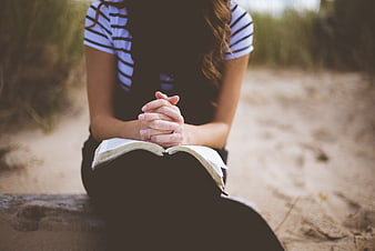 Woman Praying With Open Book On Beach