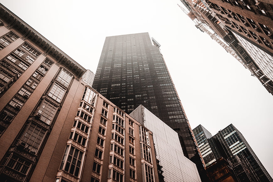 Low angle view of towering city skyscrapers against sky