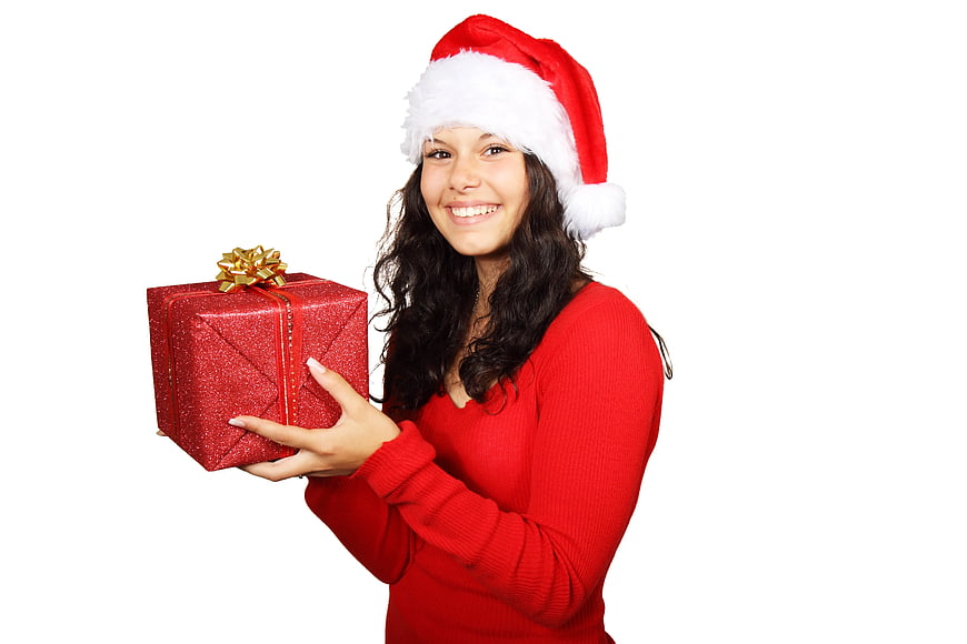Smiling Woman in Santa Hat Holding Red Christmas Gift Box
