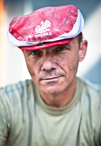 Portrait of man wearing red Polska cap with eagle emblem